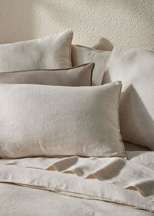 Beige bedding set with pillows on a textured surface