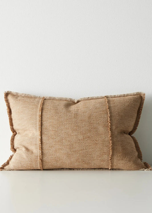 Beige pillow with textured edges on a light gray background