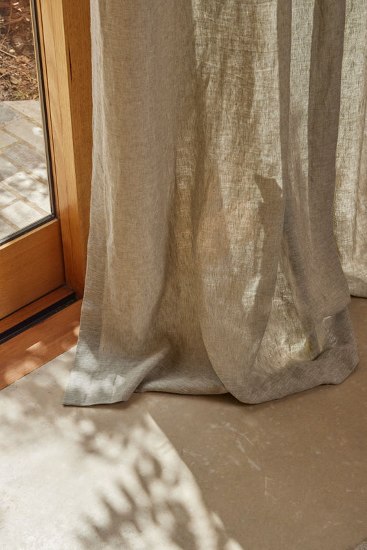 Sheer beige curtain in front of a window with natural light