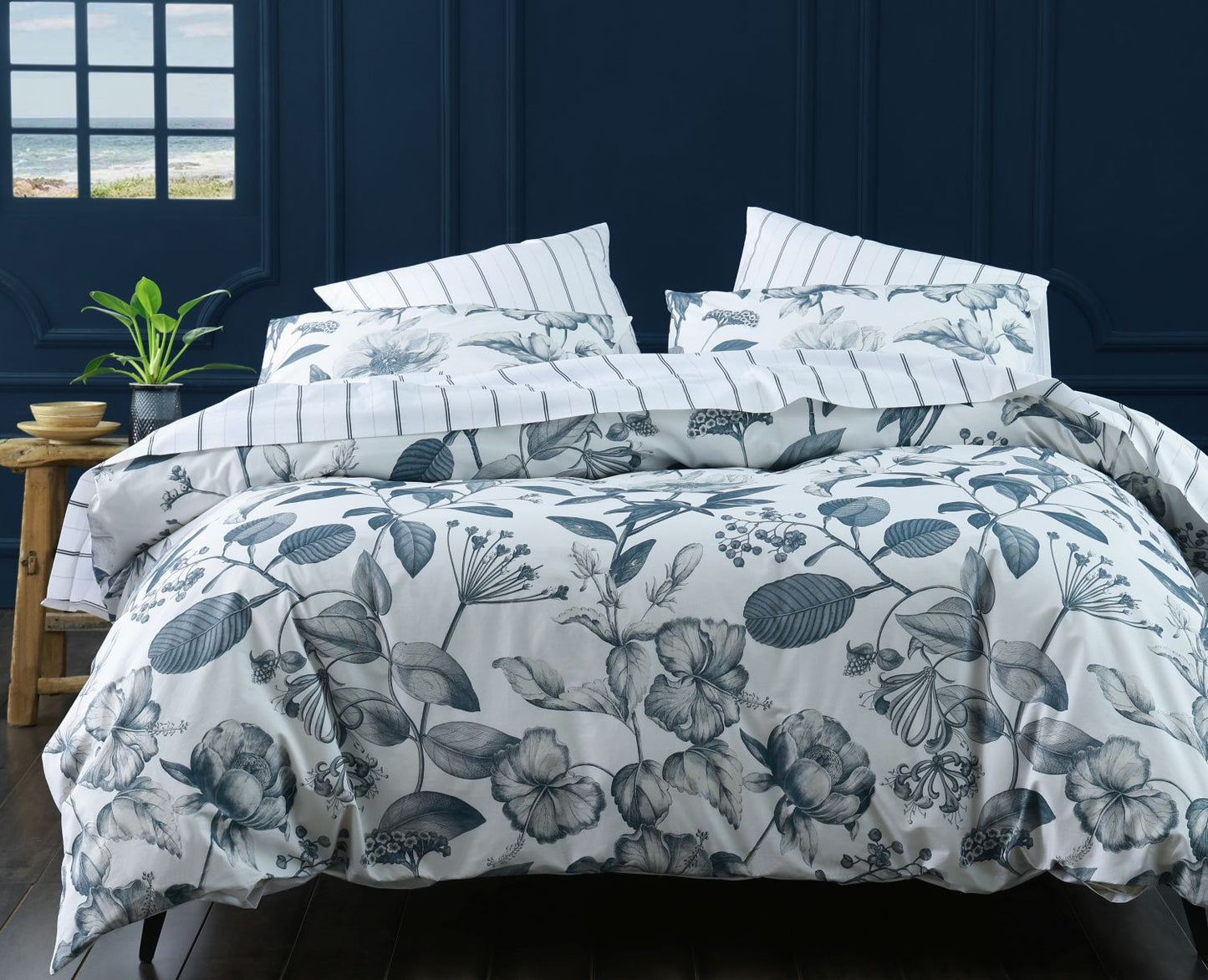 Floral patterned comforter set on a bed with a dark blue wall in the background