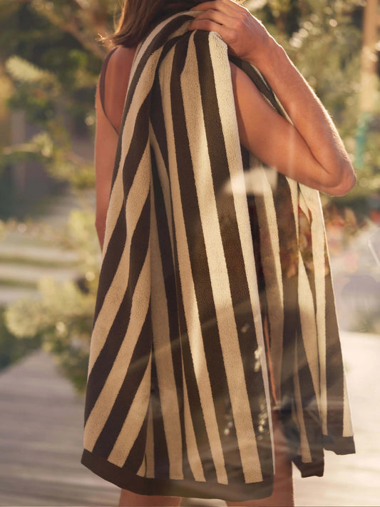 Person holding a striped towel outdoors