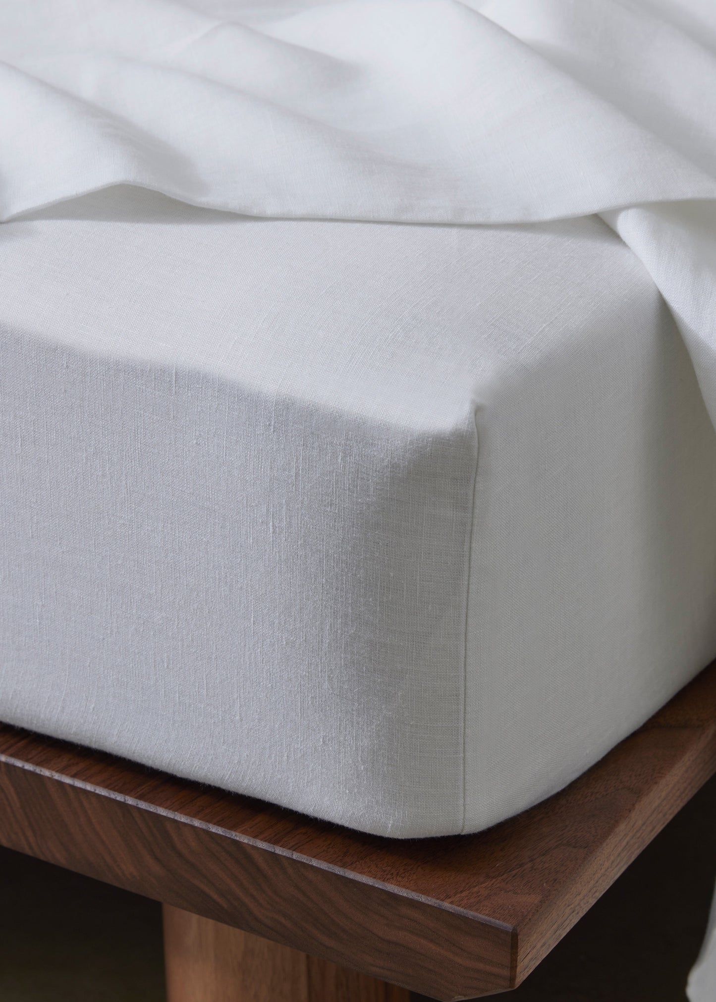 A fitted sheet made of French Flax Linen in a pure white color, displayed on a mattress.