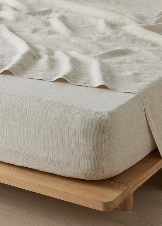 Beige bedspread on a wooden bed frame