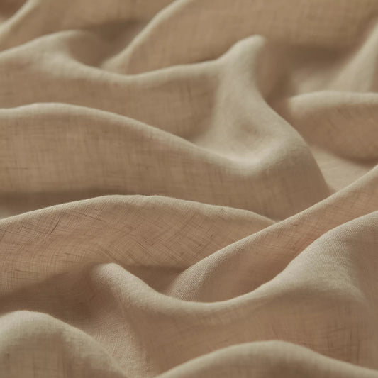 Close-up of draped beige fabric with a soft, textured weave and gentle folds.