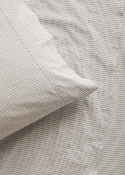 Close-up of striped bedding with a pillow corner.