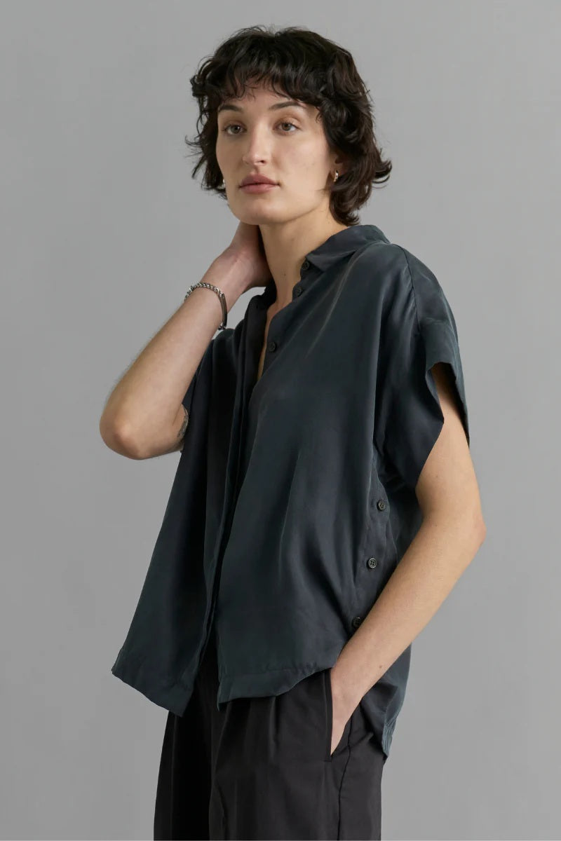 Woman wearing a black sleeveless top against a gray background