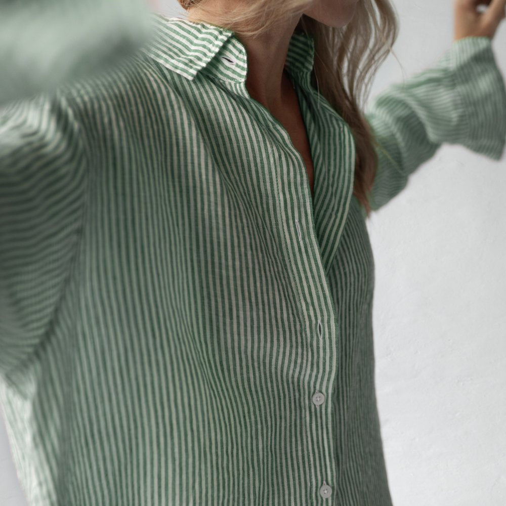Close-up of a woman wearing a green and white striped linen shirt.