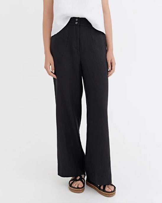 Person wearing black wide-leg pants on a white background