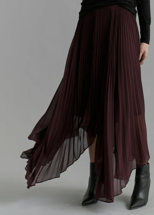 Long pleated skirt worn by a person on a plain background
