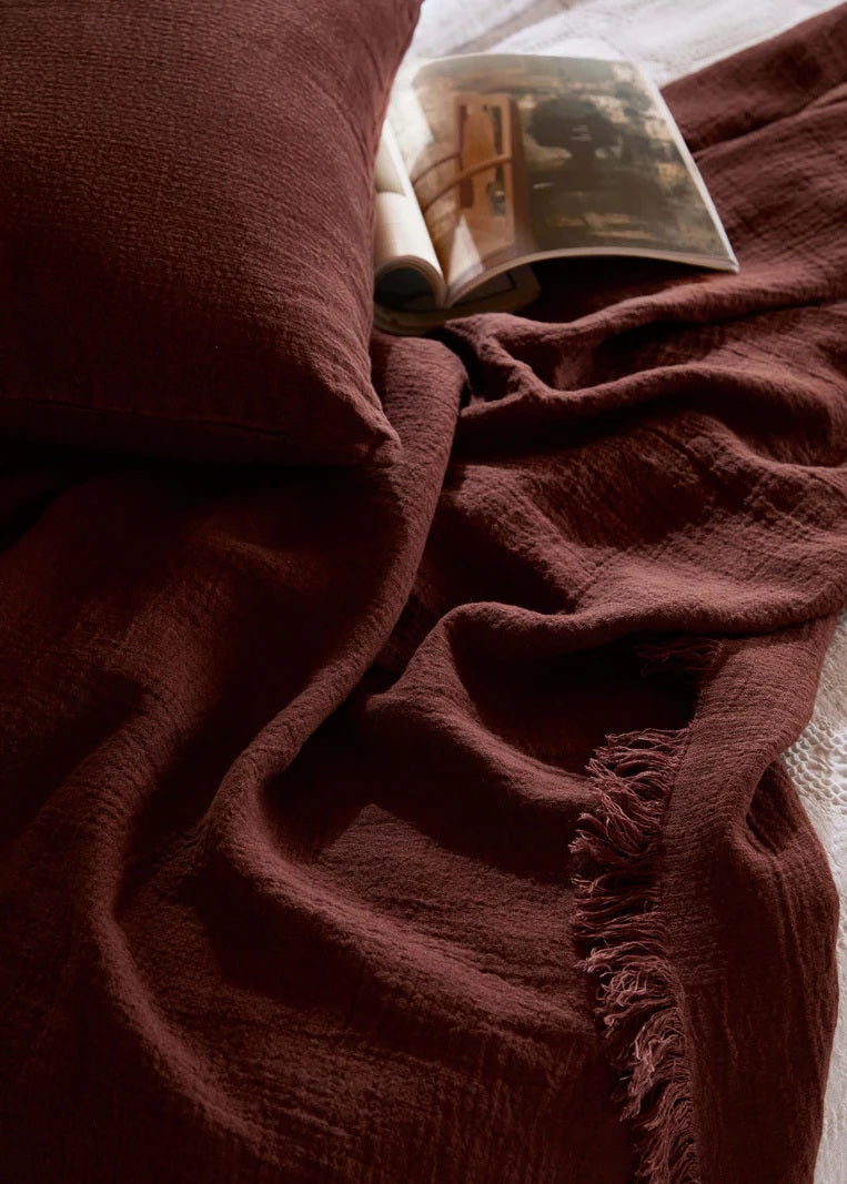 Brown fabric draped over a surface with a book partially visible.