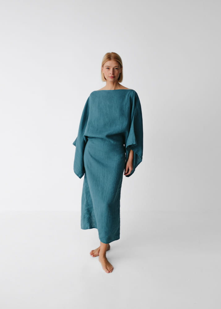 Woman wearing a teal dress on a white background