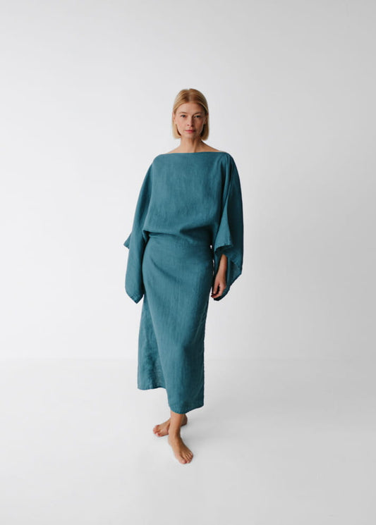 Woman wearing a teal dress on a white background