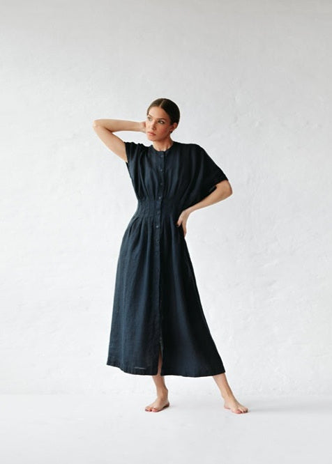 Woman wearing a black dress against a white background