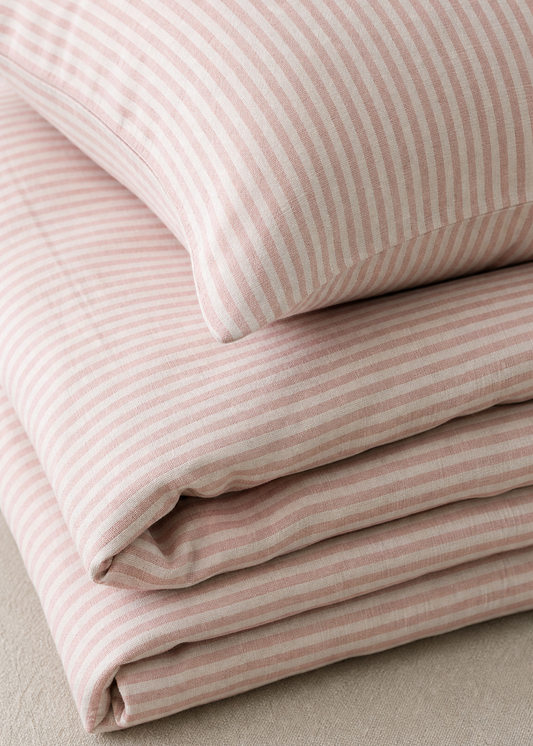 Stack of pink striped fabric on a neutral background