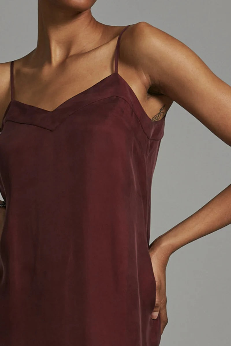 Maroon slip dress worn by a model against a neutral background