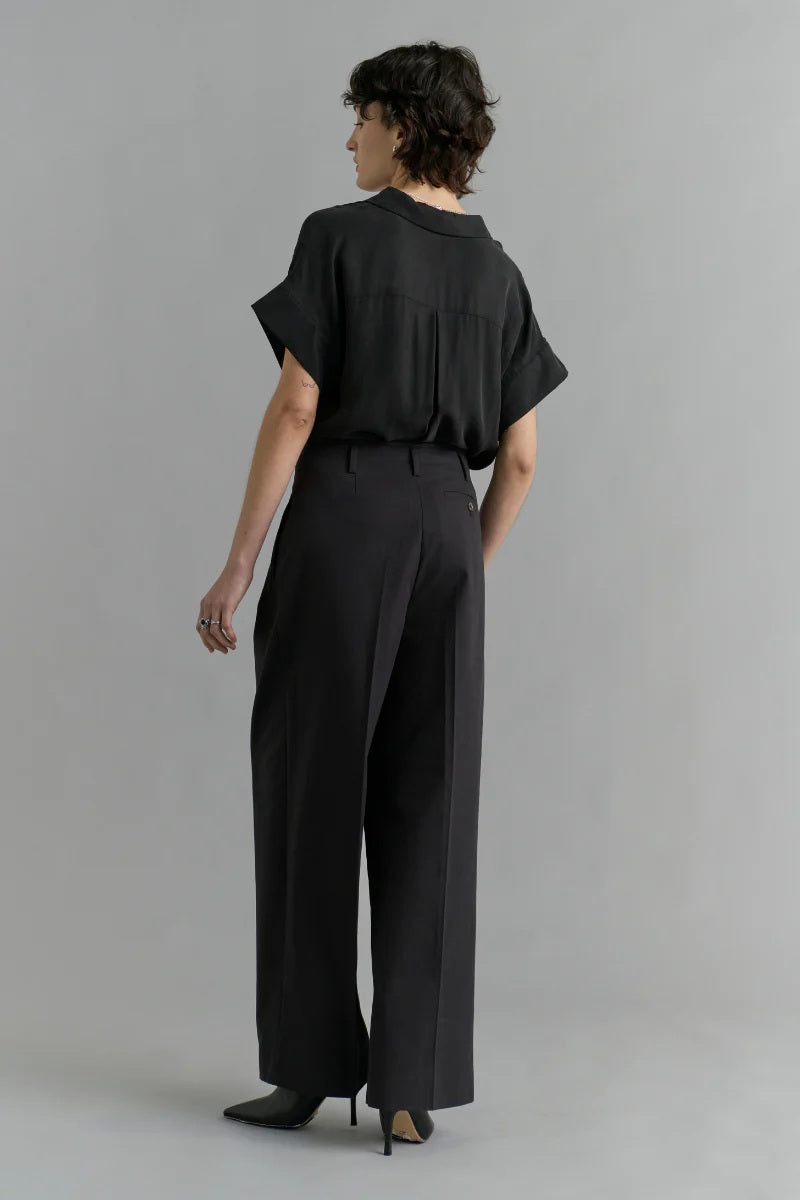 Person wearing a black outfit on a gray background