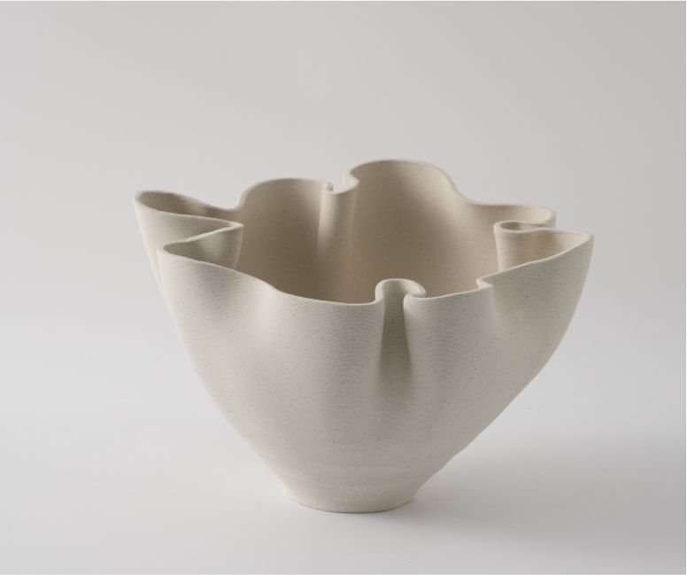 Beige ceramic bowl with wavy design on a light gray background