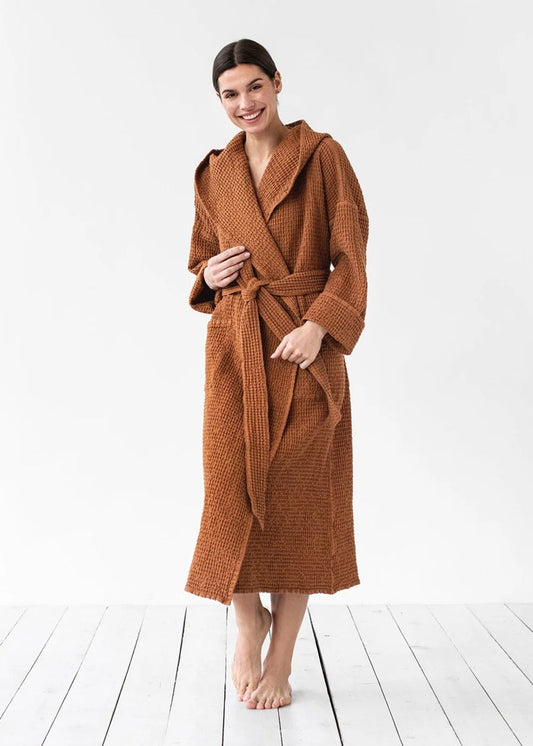 Woman wearing a brown robe on a white wooden floor