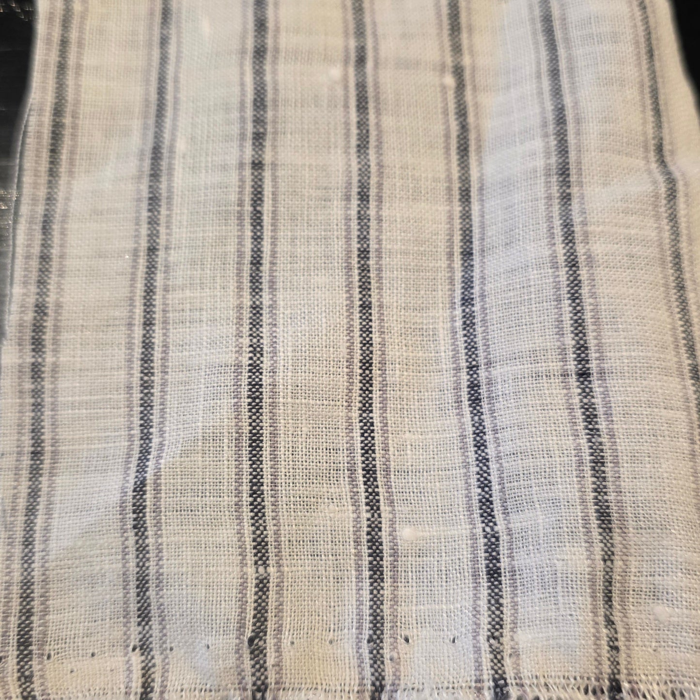 Striped fabric with black and white pattern on a dark background