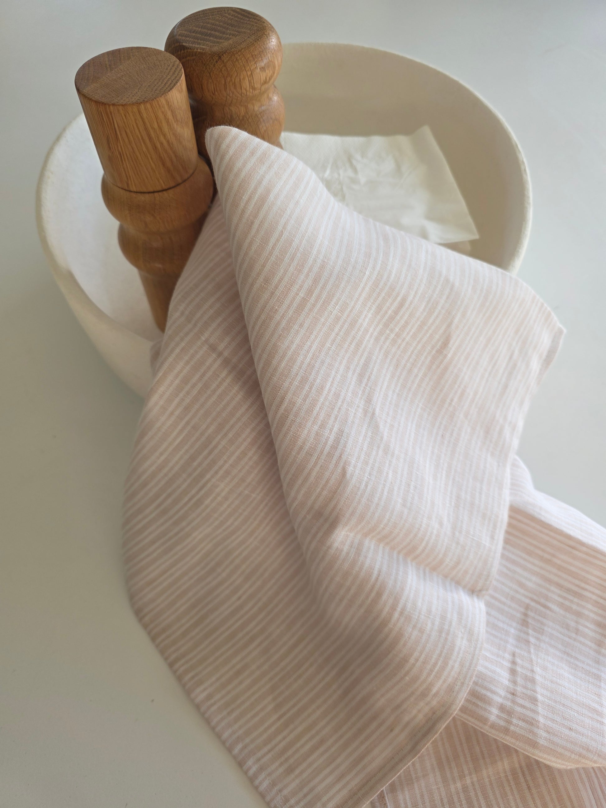 White ribbed towel draped over a wooden towel rack on a light background