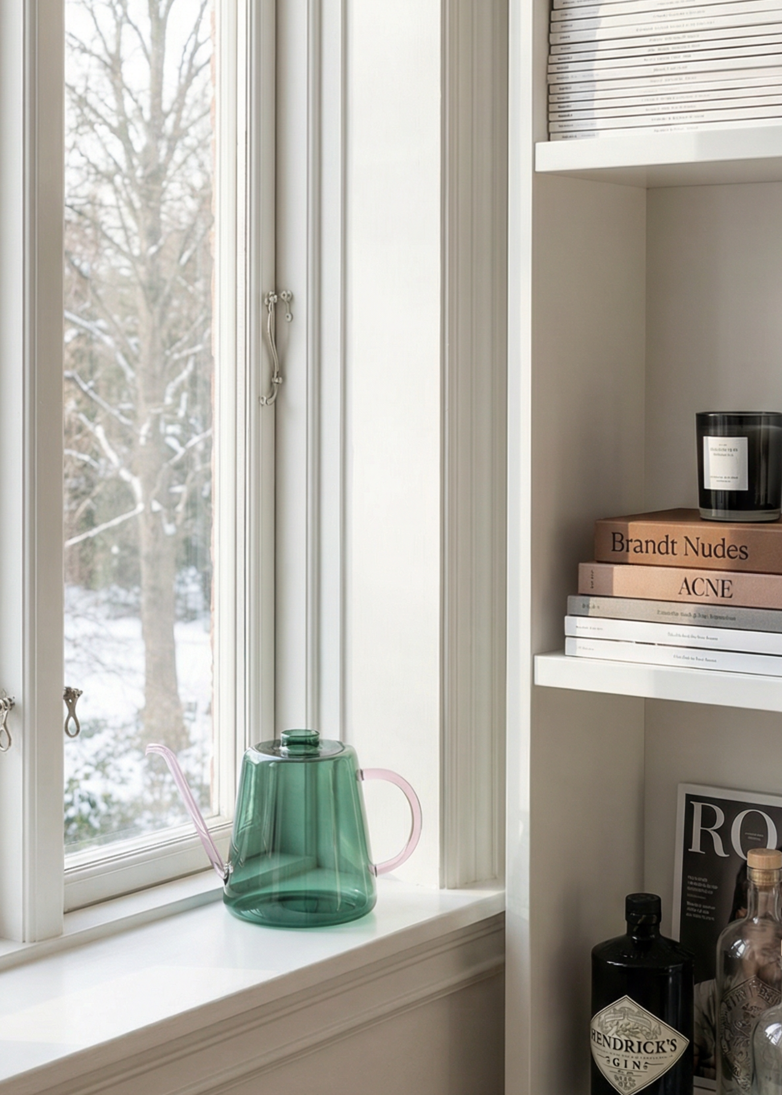 Bookshelf by a window with books and decorative items in a bright room