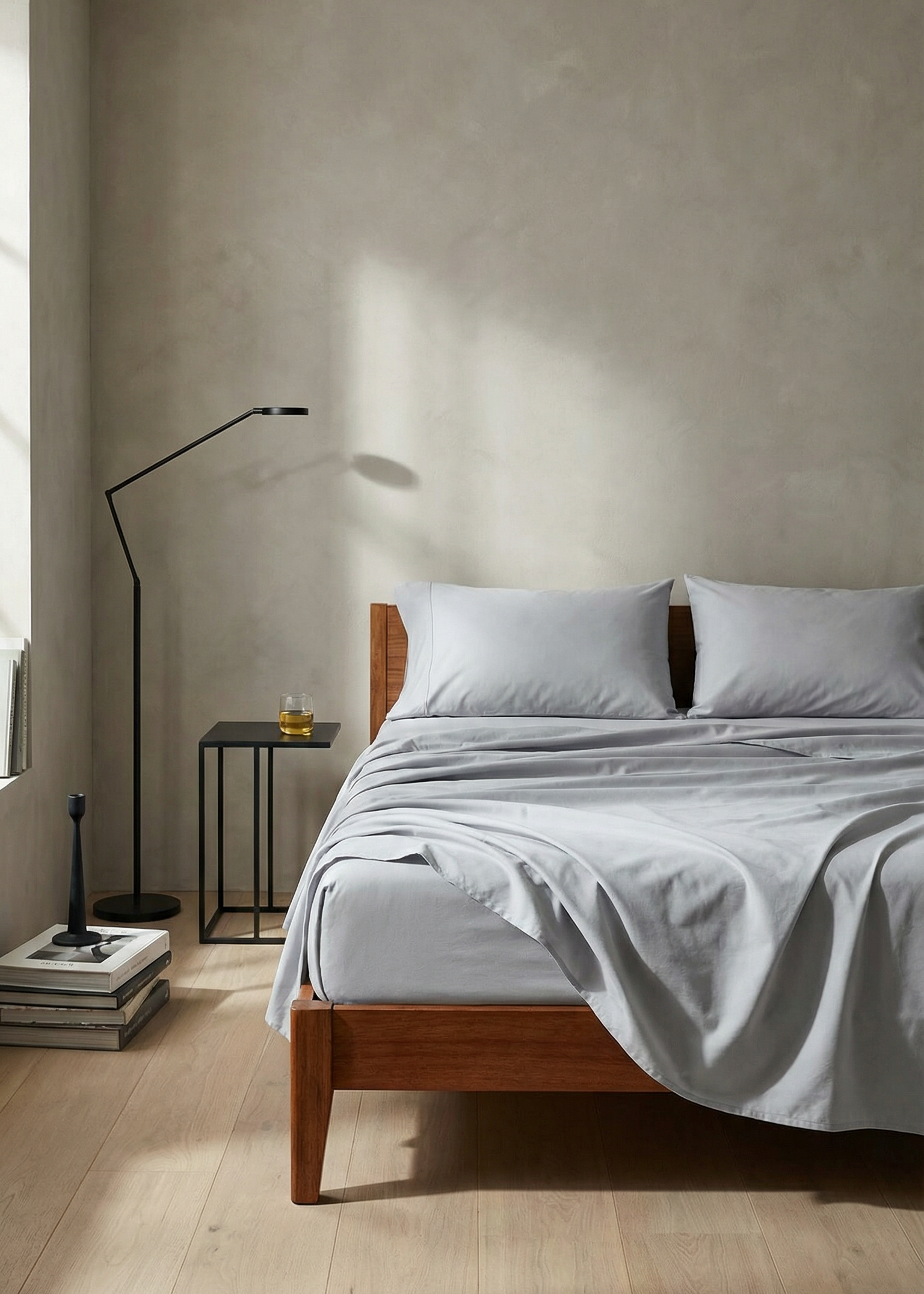 Bedroom with wooden bed frame, light gray bedding, and minimal decor.