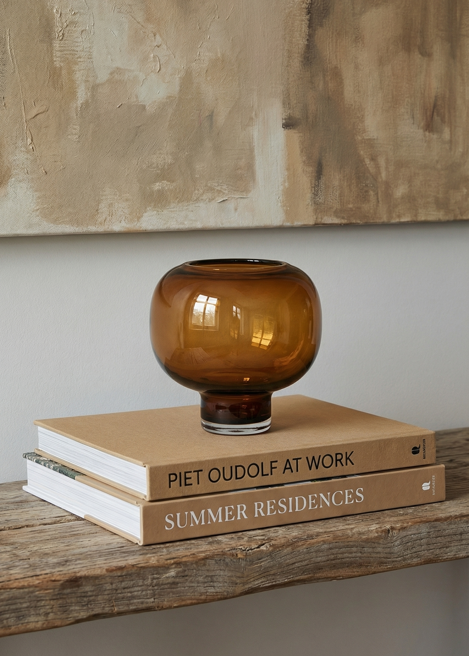 Amber glass vase on top of books with a neutral background