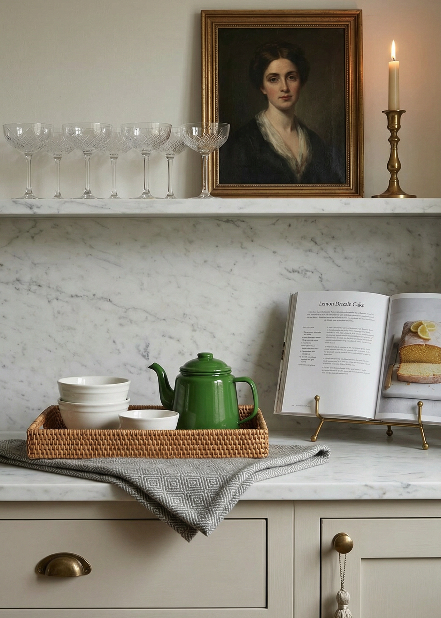 Kitchen counter with a green teapot, white bowl, and open cookbook on a marble countertop.