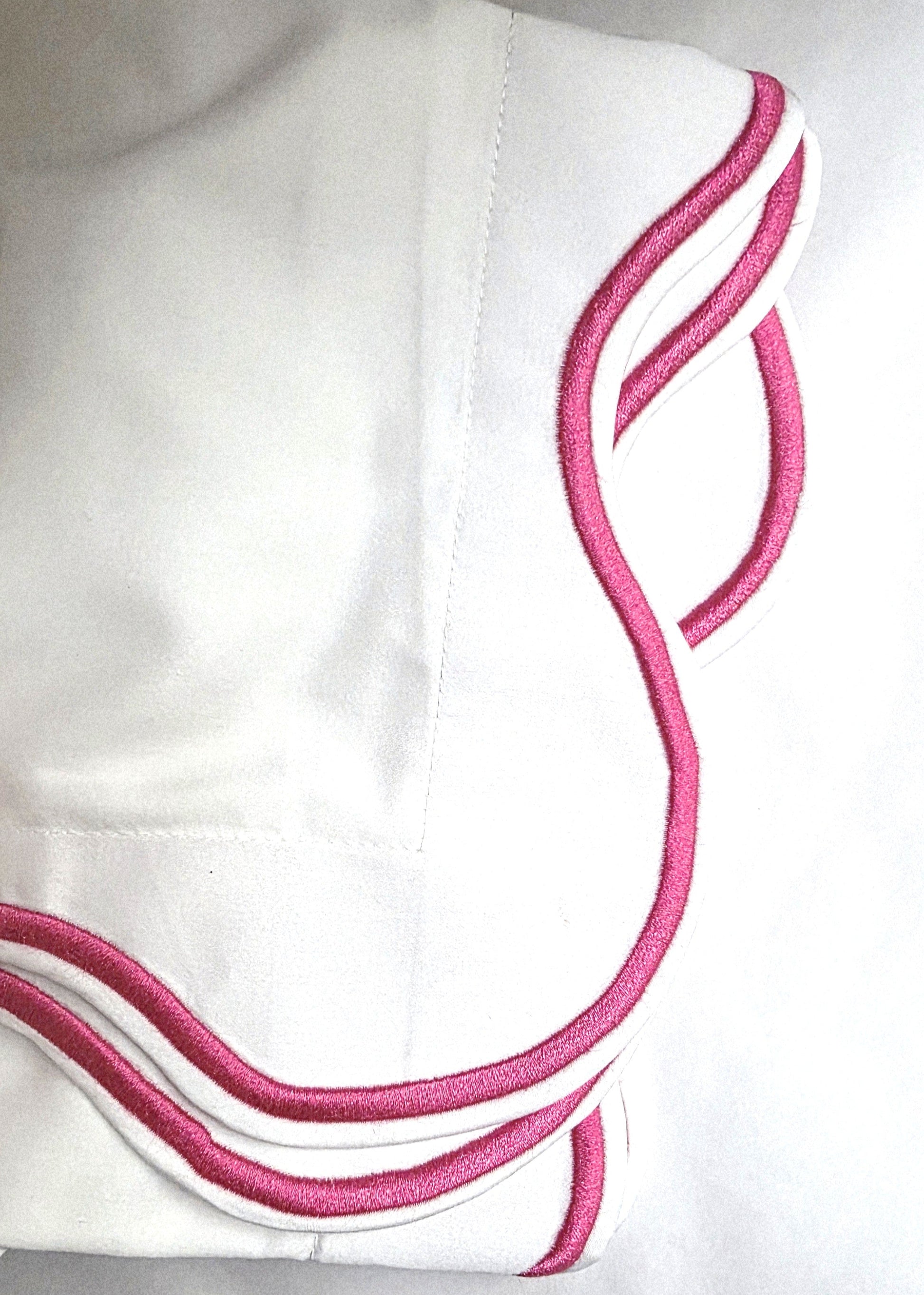 White fabric with pink embroidery on a white background