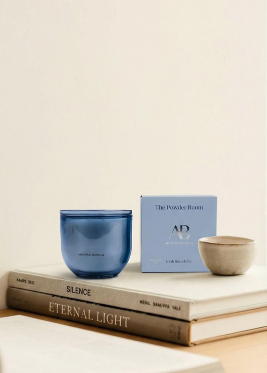 Blue candle and box on top of books with a plain background