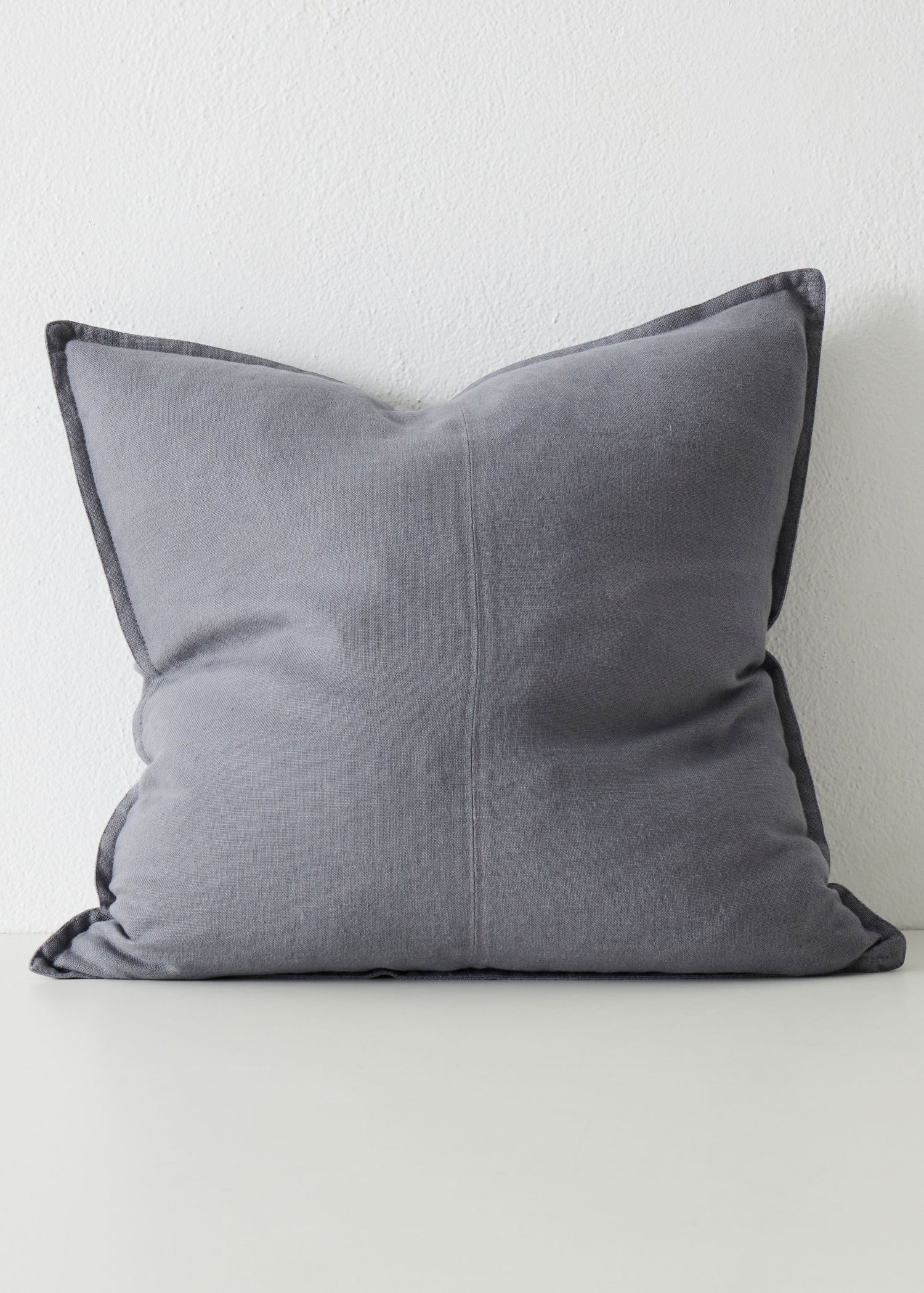 Gray pillow on a white surface with a light gray background