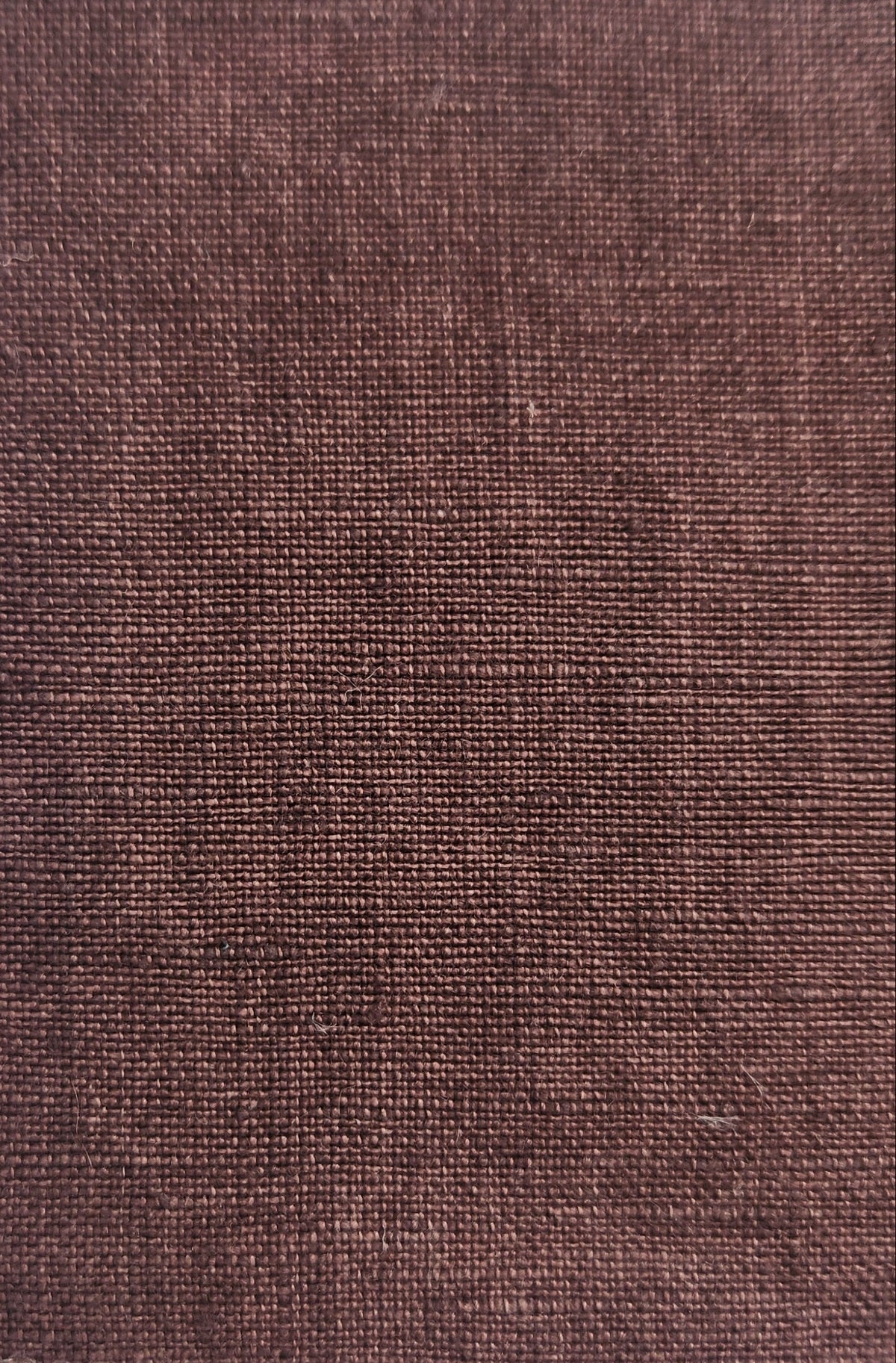 A rectangular fabric swatch with scalloped edges, showing a textured woven material in a muted dusty rose or mauve color, set against a plain light background.