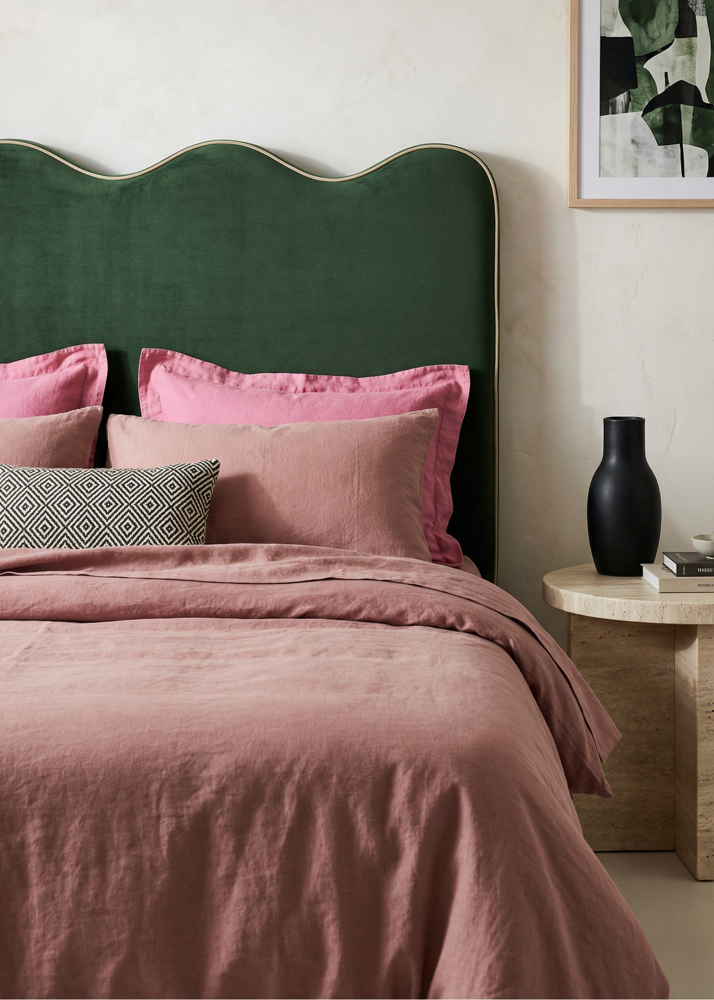 Bedroom with green headboard, pink bedding, and a framed picture on the wall.