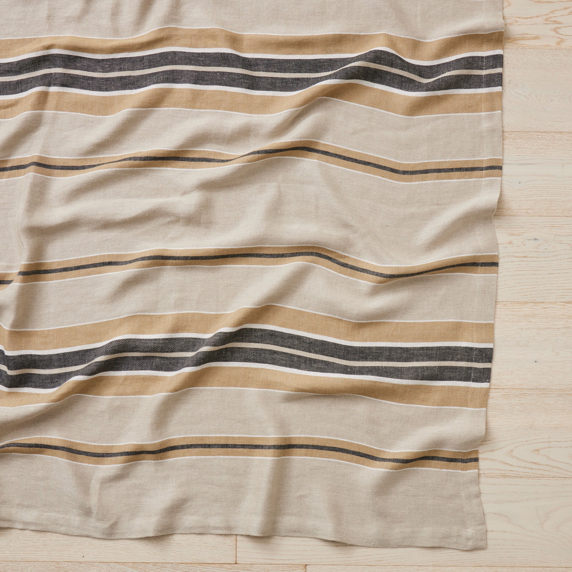 Beige fabric with horizontal stripes on a wooden surface