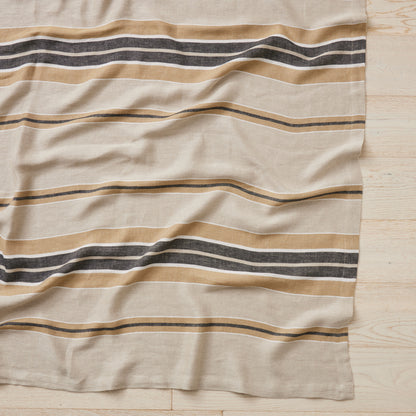 Beige fabric with horizontal stripes on a wooden surface