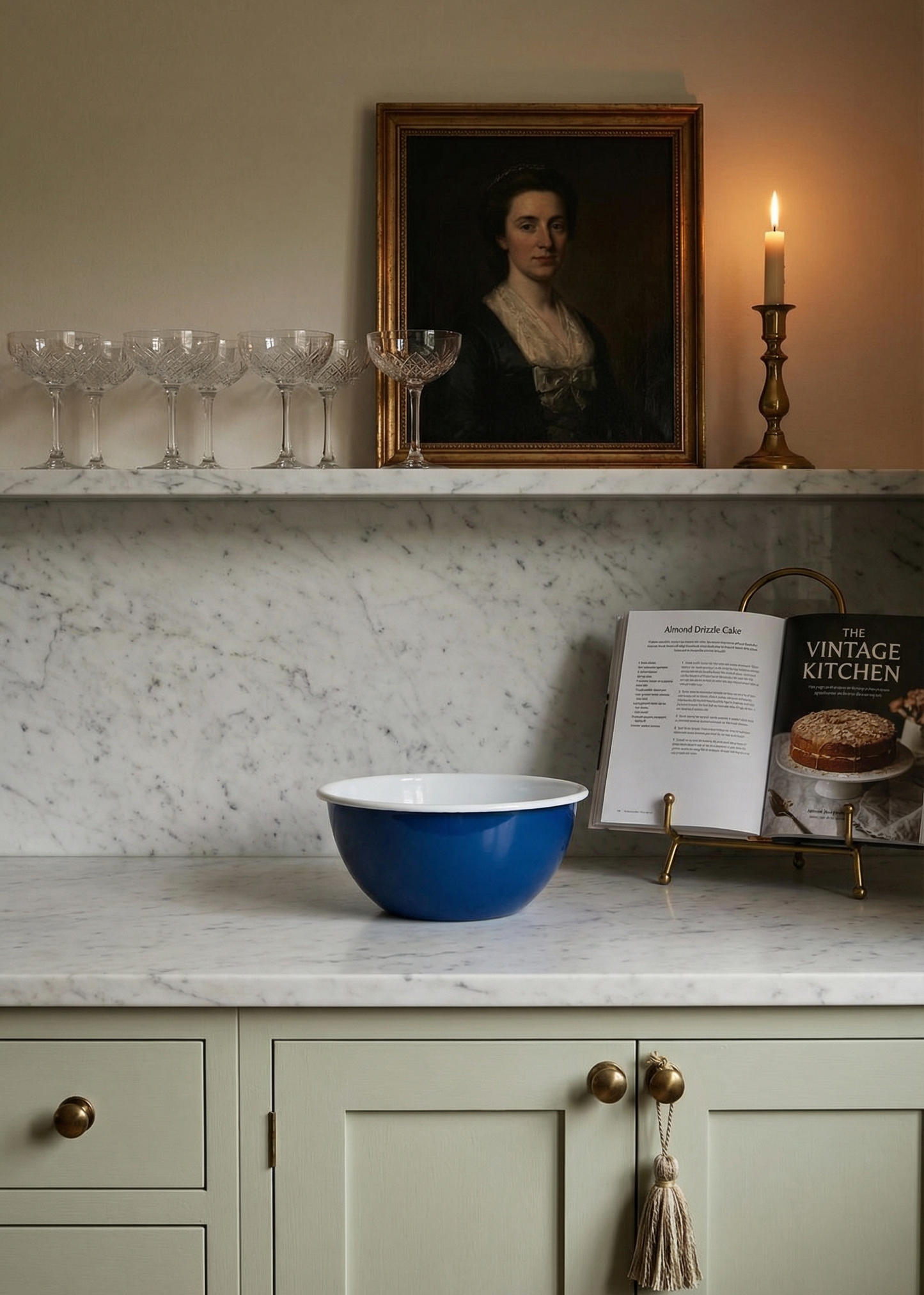 Blue mixing bowl on a kitchen counter with a portrait and candle in the background.