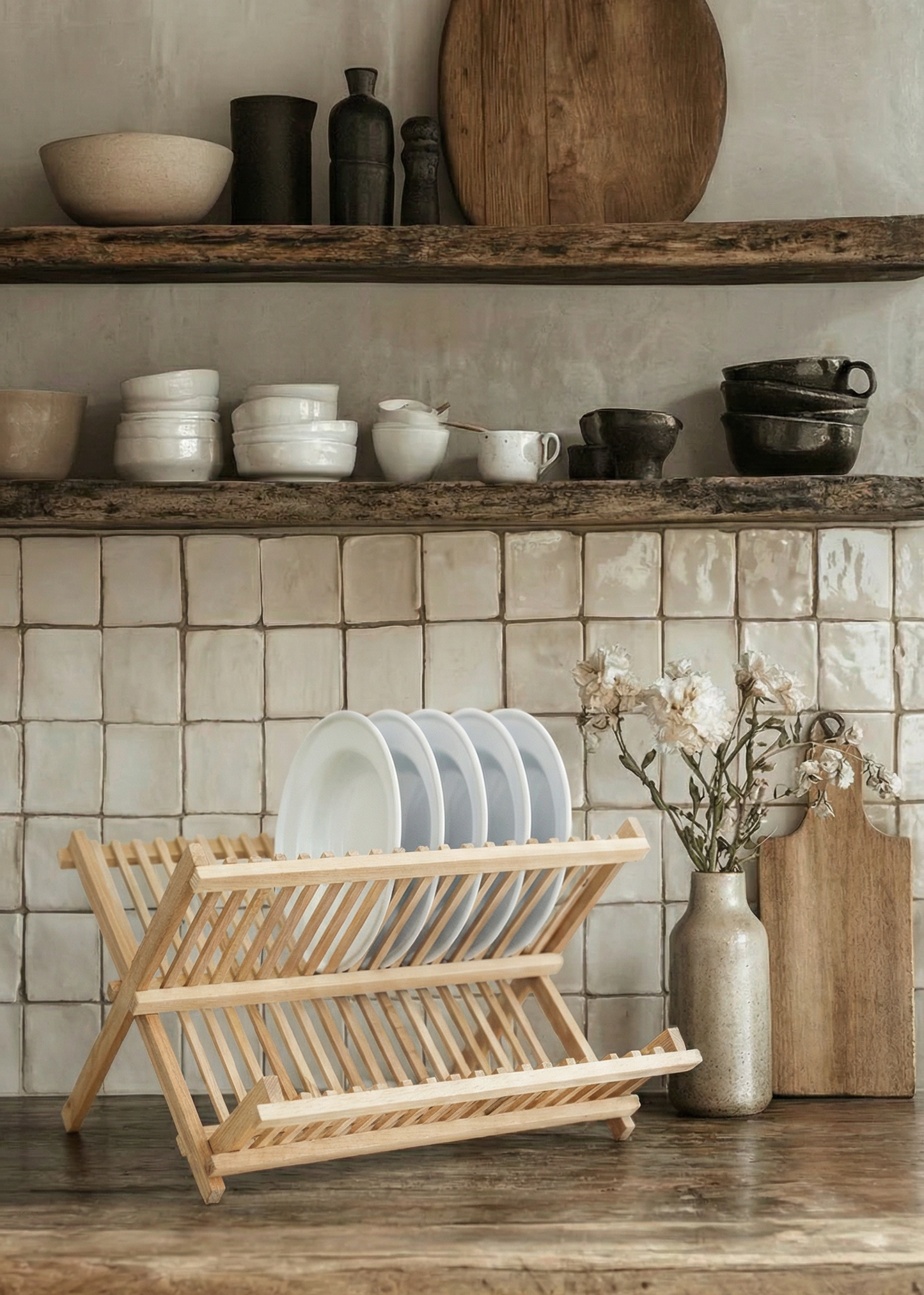 Dish rack with dishes on a wooden shelf against a tiled wall.