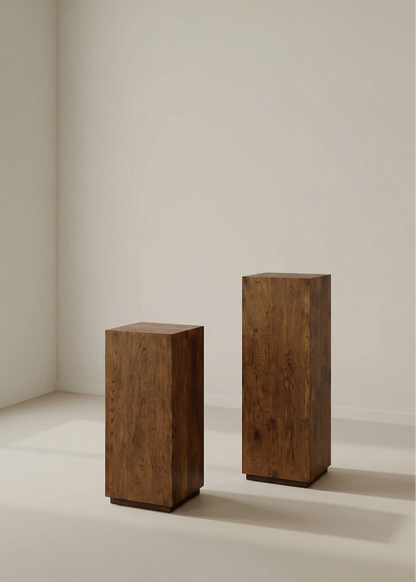 Two wooden pedestals on a light-colored floor with a neutral wall background