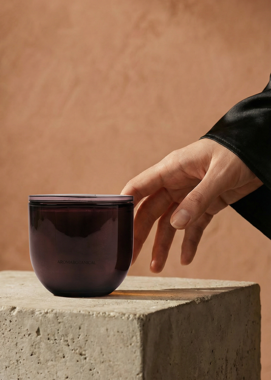 Hand reaching towards a dark ceramic cup on a concrete surface with a neutral background