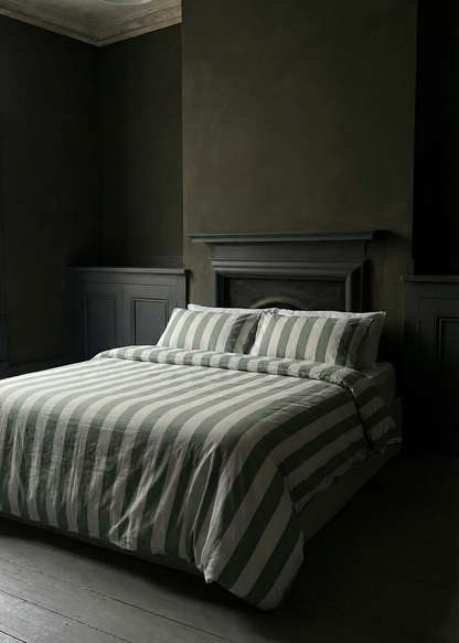 Dark bedroom with striped bedding and wooden floor