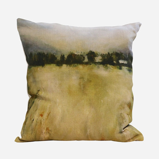 A square decorative throw pillow featuring an abstract landscape print in muted beige, olive green, and dark forest tones, shown against a plain light gray background.
