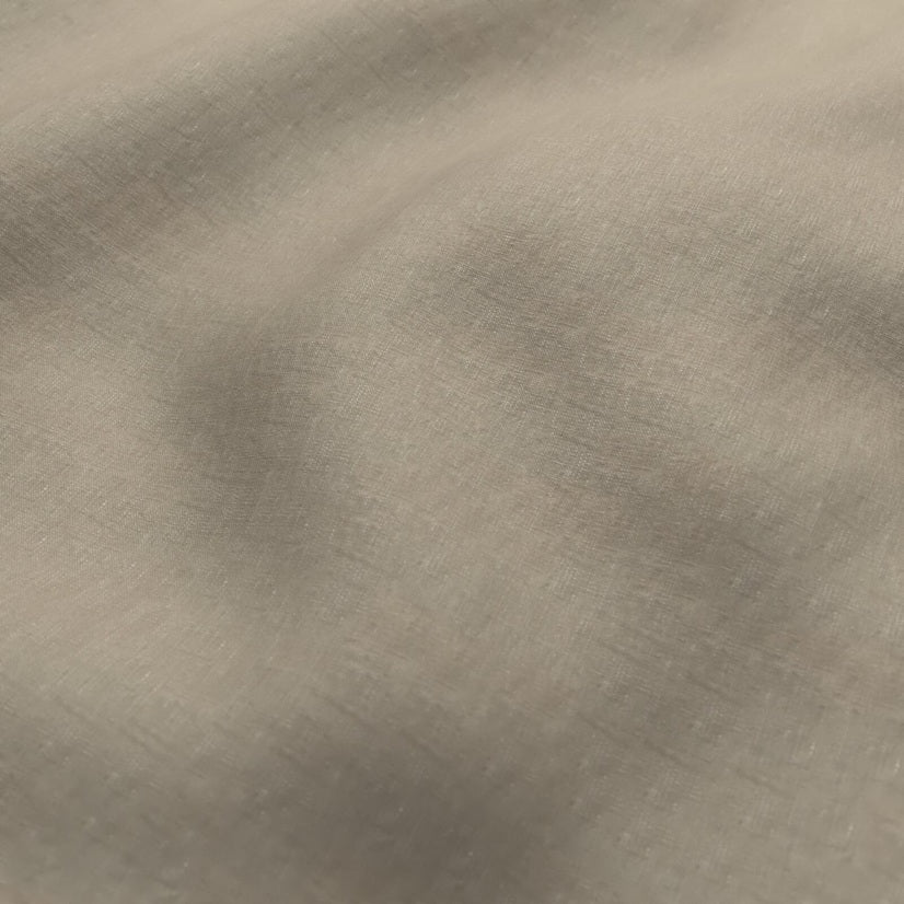 A close-up of a textured fabric with a soft, brushed metallic finish in a warm taupe or champagne color.