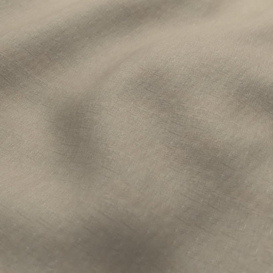 A close-up of a textured fabric with a soft, brushed metallic finish in a warm taupe or champagne color.