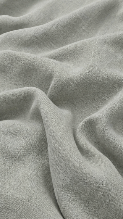 A close-up of draped light gray fabric with a soft, slightly textured weave and gentle folds.