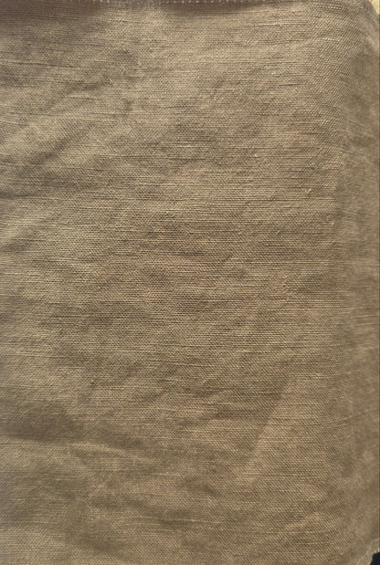 A square piece of tan woven fabric or felt material with a coarse, textured surface, laid flat on a white lined notebook page.