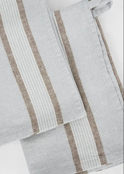 Two striped towels with brown and white stripes on a light gray background