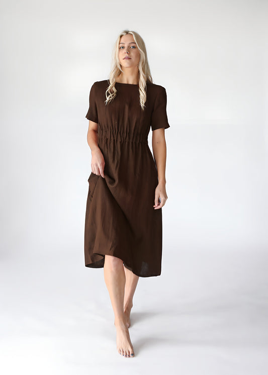 Woman wearing a brown dress on a white background