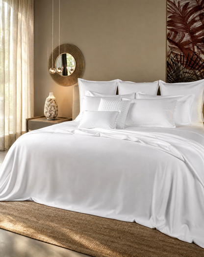 Neatly made bed with white bedding in a bedroom setting.