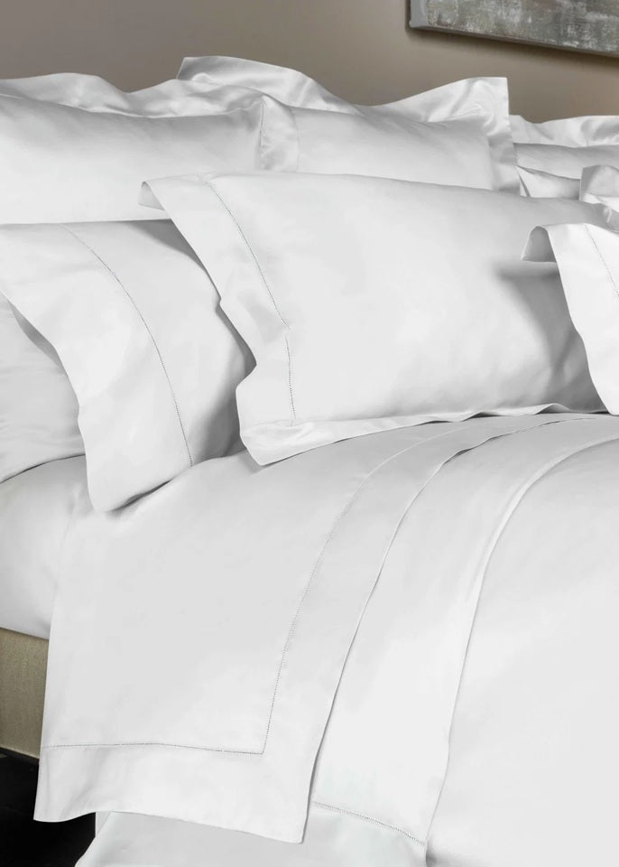 White bedding set with pillows on a bed