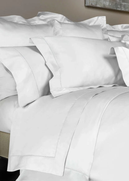 White bedding set with pillows on a bed